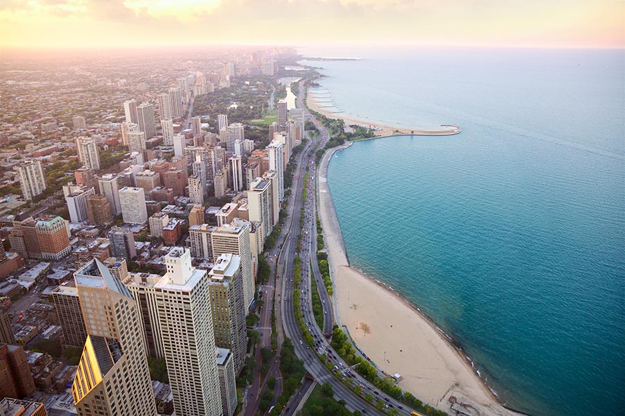 Chicagoland Insurance - Aerial View of Chicago and Lake Michigan at Dusk, the Sky Turning Orange and Reflecting off of Buildings